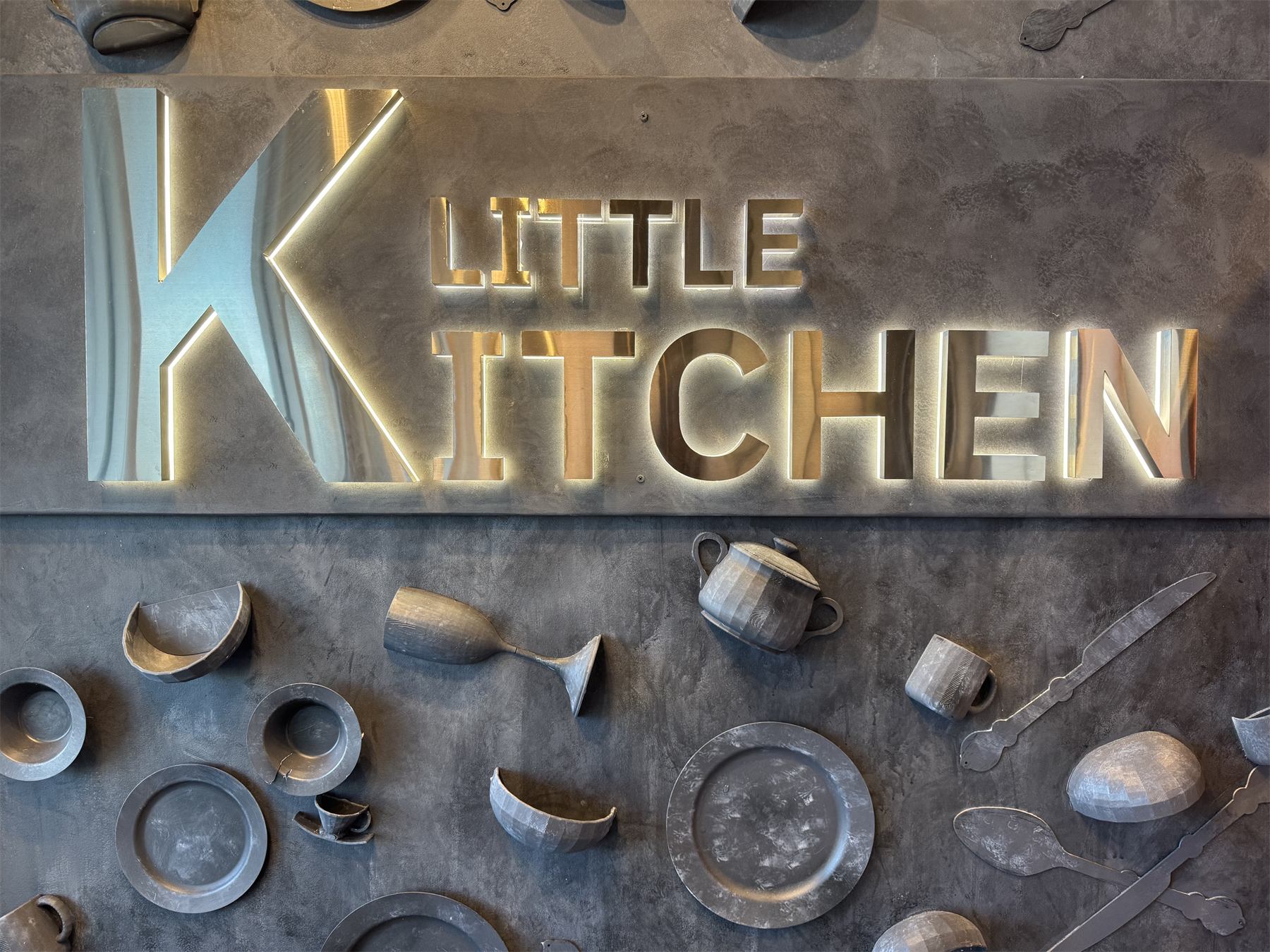 The backlit Little K Kitchen sign inside the restaurant in League City, TX